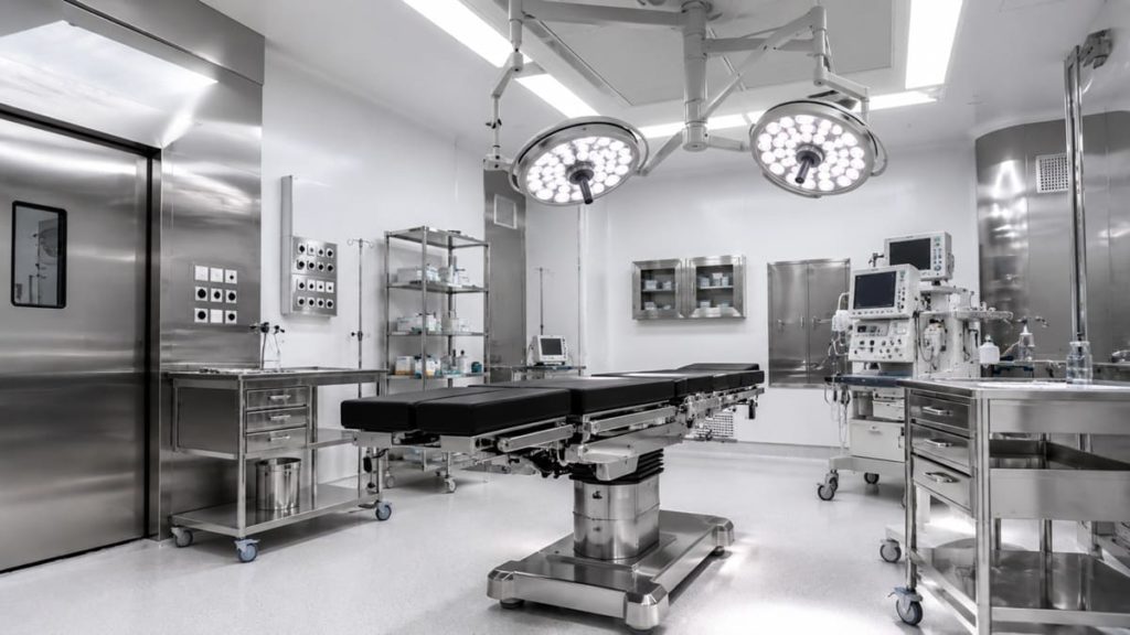 Bloc opératoire moderne avec surfaces en inox 316L sur table d’opération, chariot médical et équipements chirurgicaux